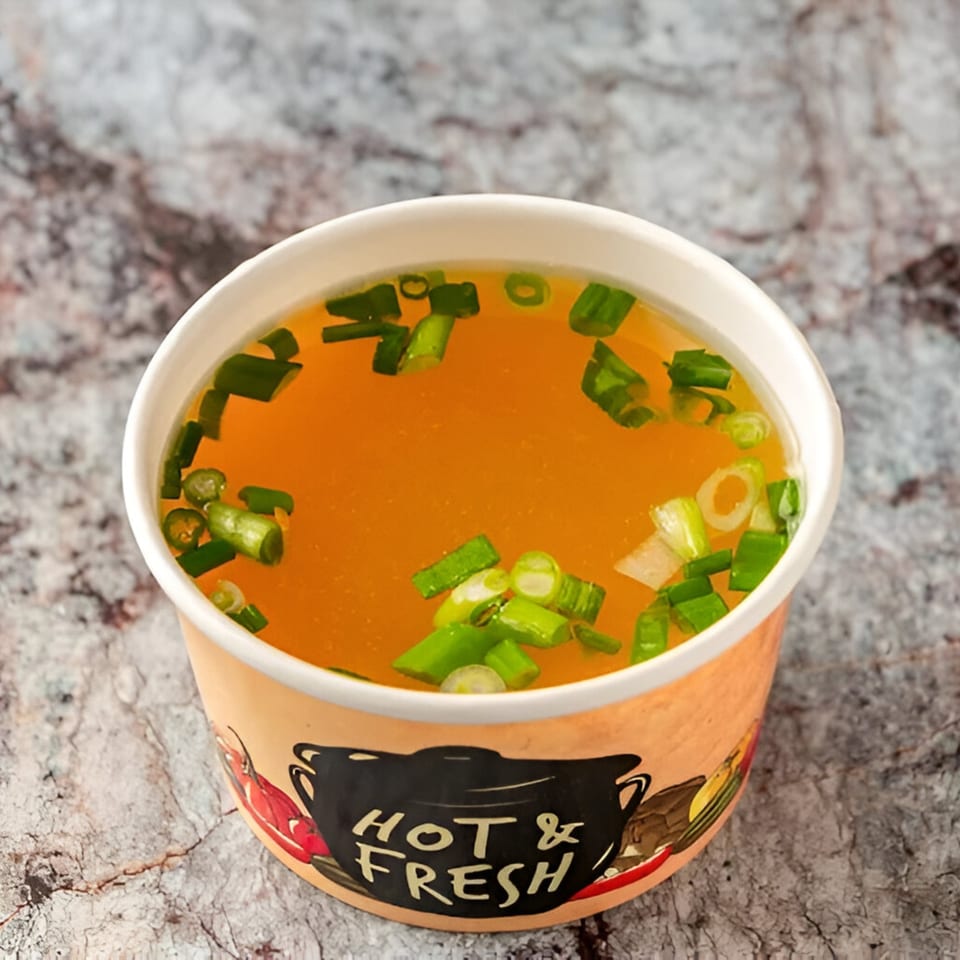 A cup of hot broth with chopped green onions from PokeCity Greenwood Village.